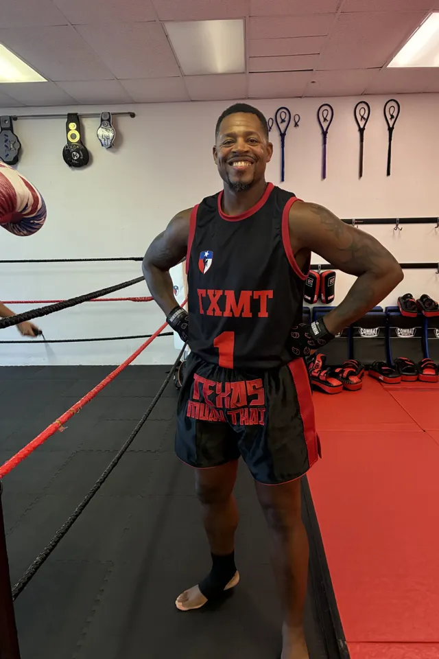 Coach Bryce Granger smiling in the ring in a TXMT jersey