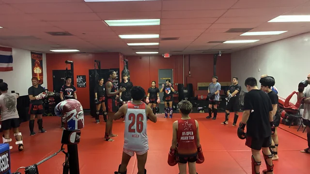 Kids gather with their coach inside the Texas Muay Thai gym